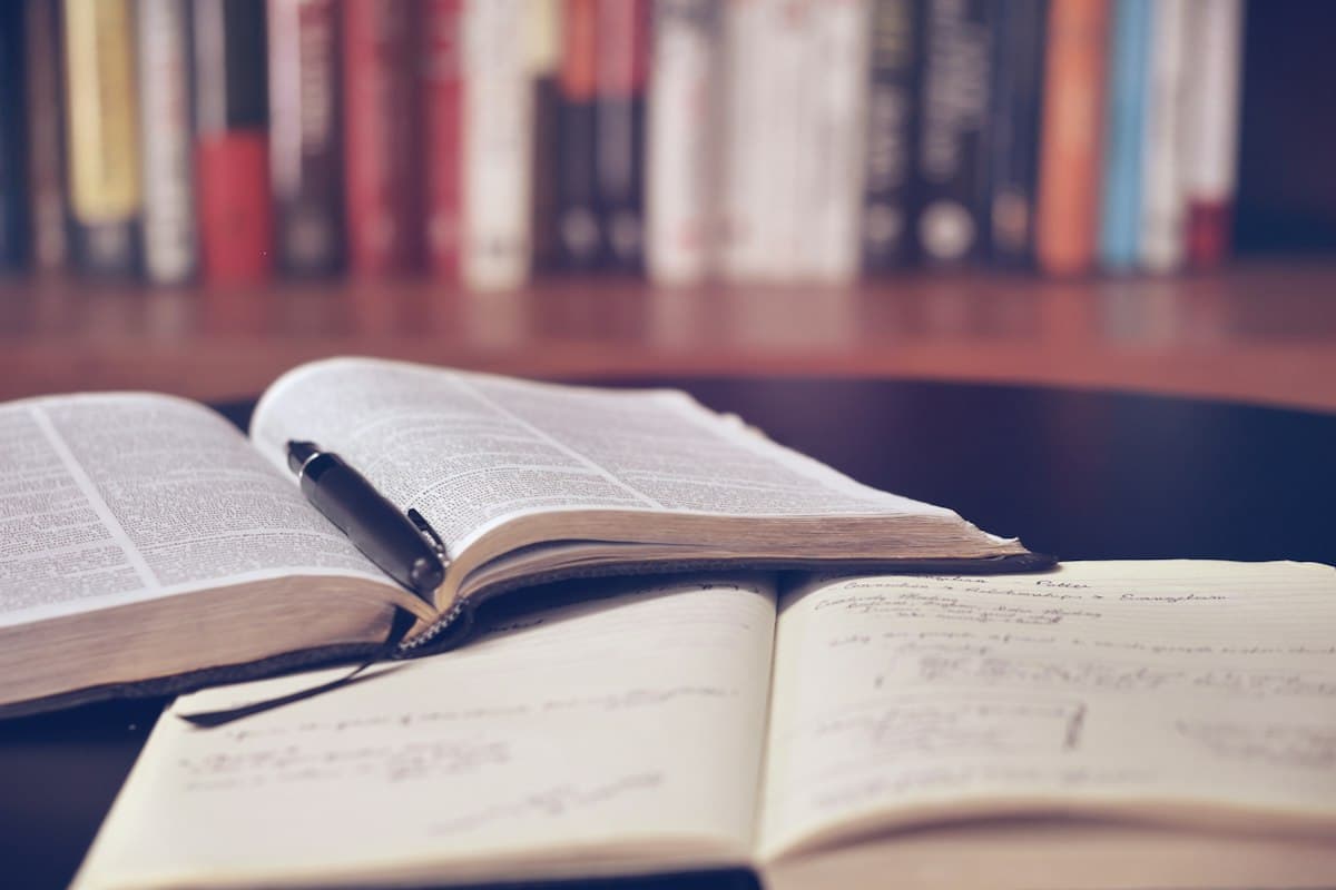 Academic study table with textbooks, notebook, and writing instruments
