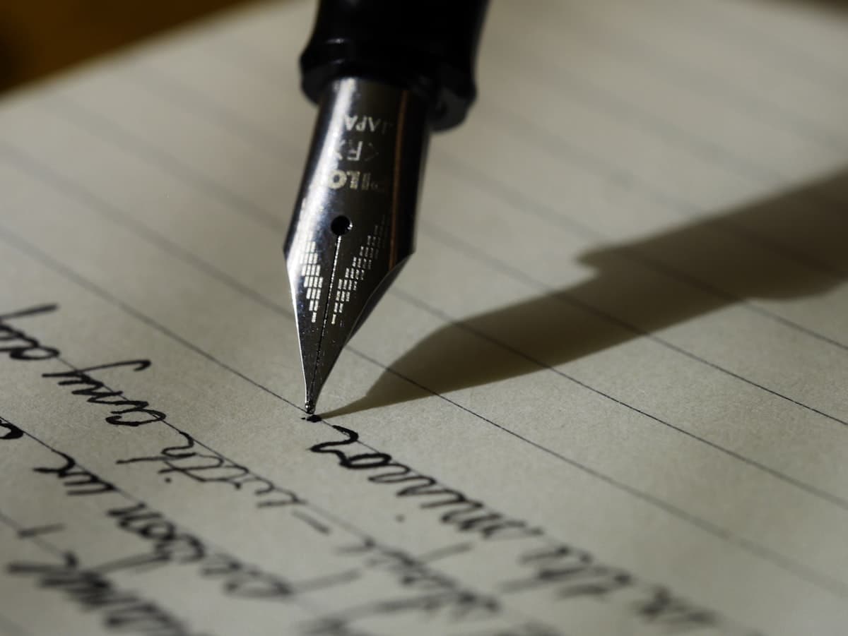 Hand holding a pen editing printed text in a notebook