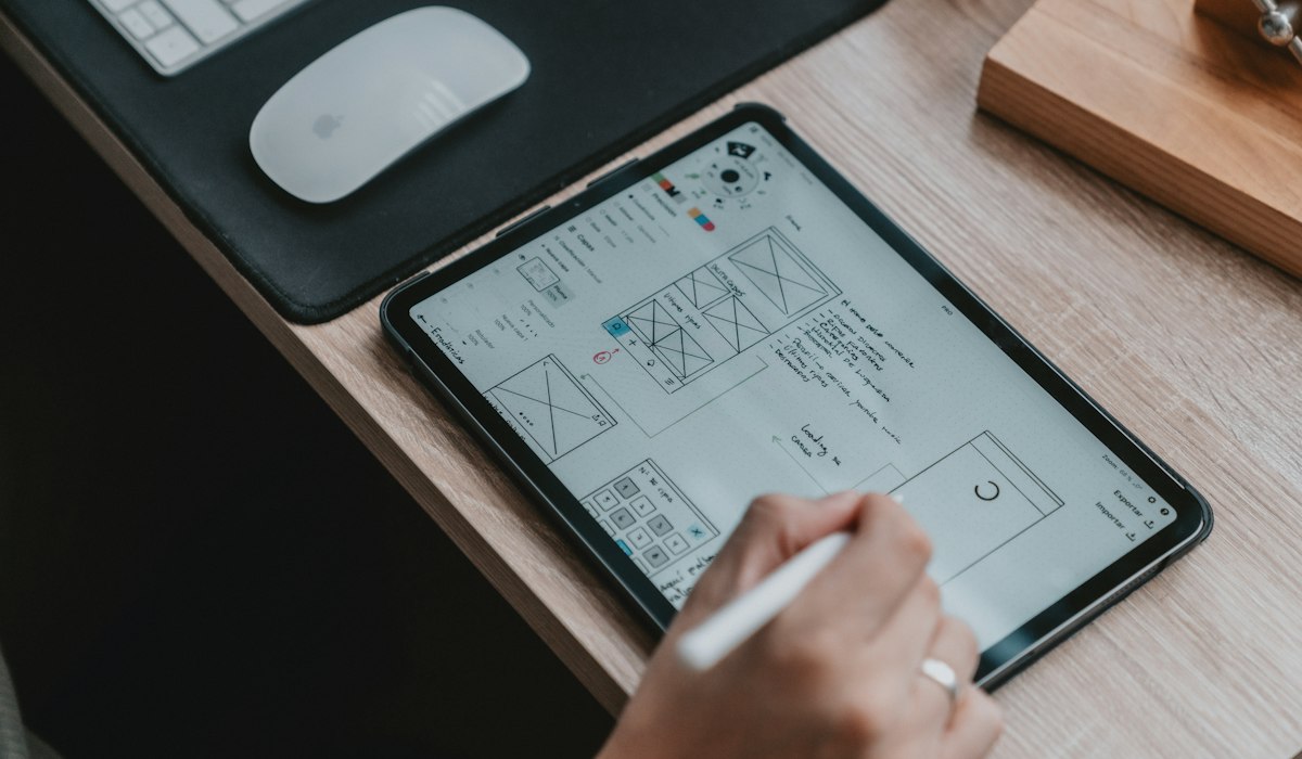 Wireframe layouts and accessibility color palettes on a designer workspace