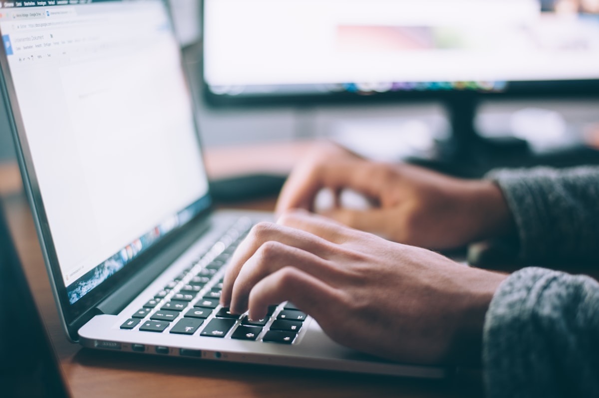 Author editing a draft manuscript with a laptop